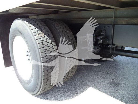 Truck rear axle area with dual tires, suspension components, and undercarriage. Visible text includes VIN and stock info from listing but not readable on the image itself beyond generic truck parts.