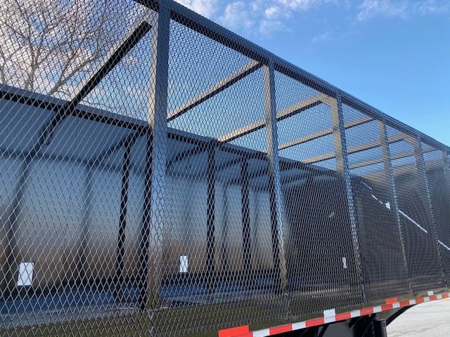 Crush car carrier trailer with mesh side panels and open top, 2008 Transcraft 48 ft. side mesh fencing visible along trailer.