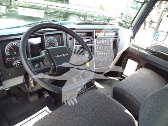 Mack MD6 truck interior showing steering wheel, dashboard gauges, and center console with control buttons.