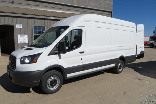 White 2015 Ford Transit cargo van in a parking lot, side view showing long wheelbase, no windows on side panels, black front bumper and gray lower body trim.