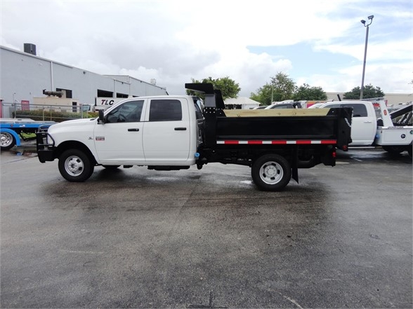 2012 Ram 3500 SLT dump truck side view showing dump bed and white cab.