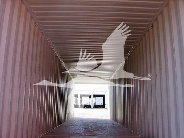 Container interior showing double doors at far end and open space with light at the doorway.