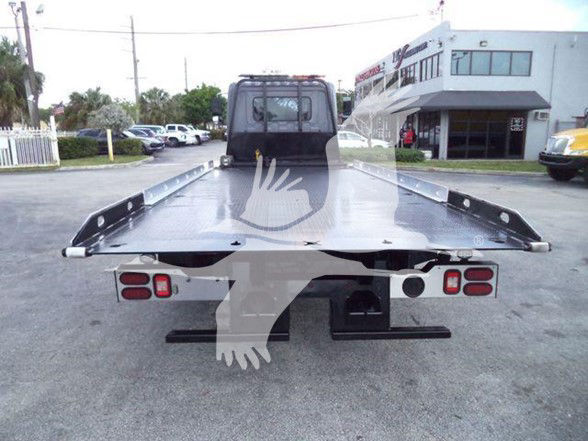 Flatbed tow truck bed rear view with taillights and winch housing visible