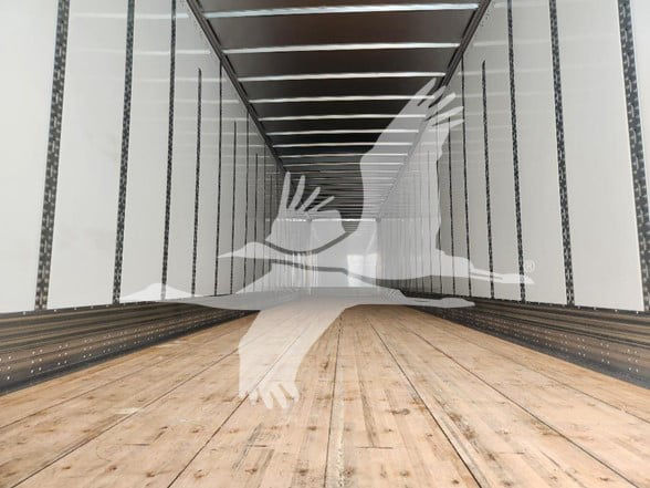 Interior of a Wabash van trailer showing wooden floor and white walls with support beams.