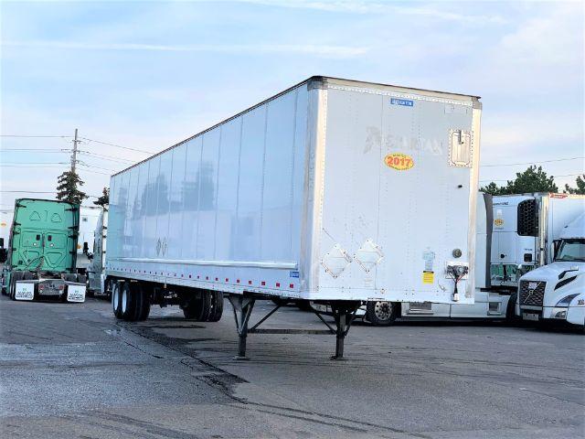 2017 Stoughton dry van trailer in a lot, front-right corner visible, stock number 8445, label stickers on the door area.