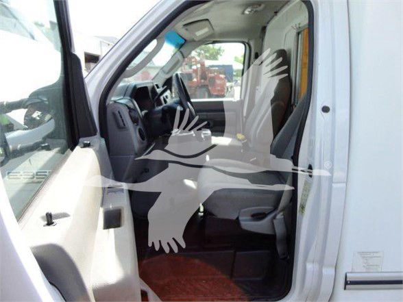 Ford E-350 Super Duty interior cabin with front bench seat, passenger door open, showing steering wheel and dashboard.