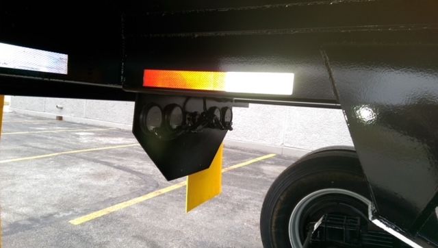 Great Dane dump trailer undercarriage showing tag/chute and rear axle with reflective safety marks.