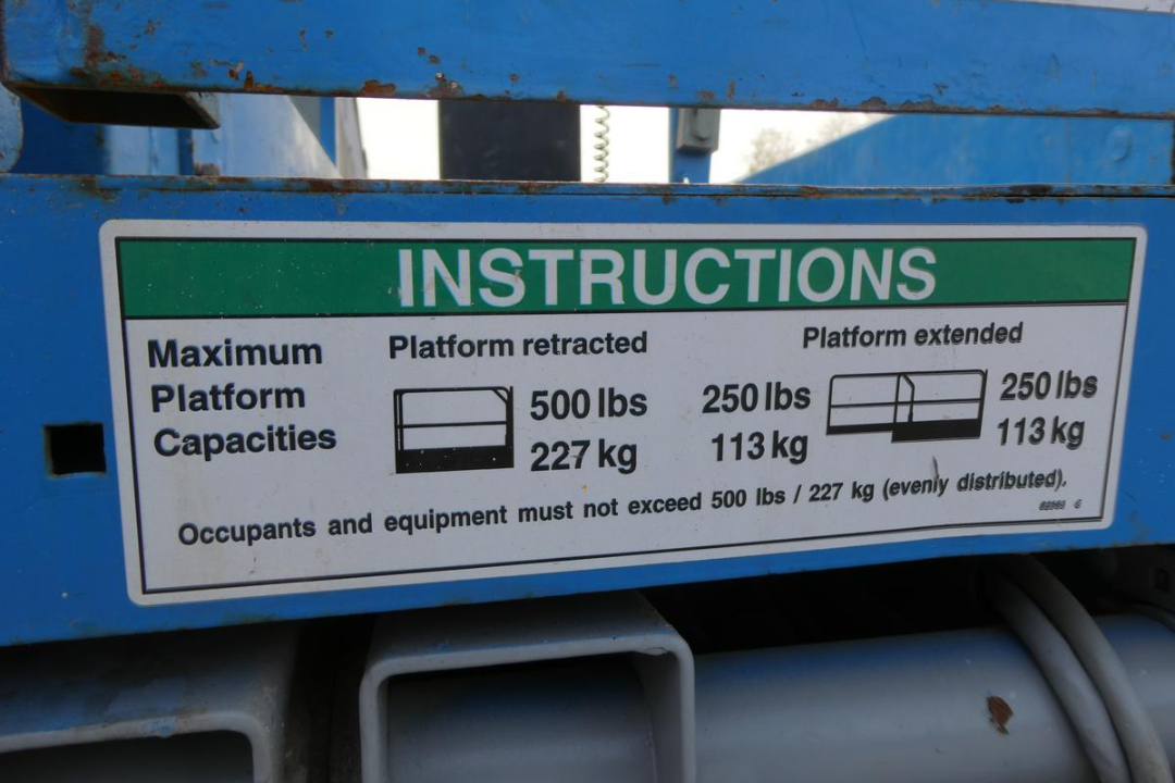 INSTRUCTIONS label on Genie GS1930 platform showing maximum platform capacities: platform retracted 500 lbs (227 kg), platform extended 250 lbs (113 kg).