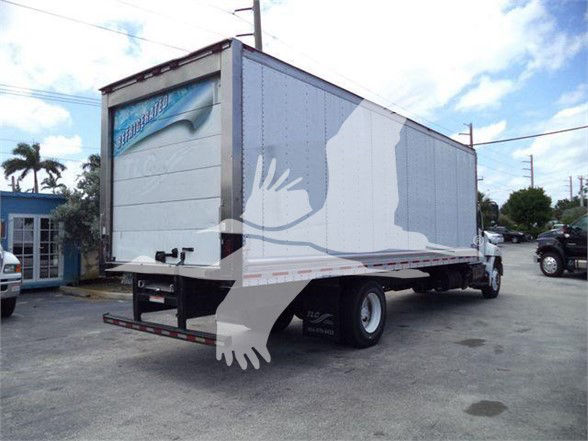 Truck trailer in a rear three-quarter view showing a large insulated box with a light gray/blue exterior and a white cab, under a partly cloudy sky.