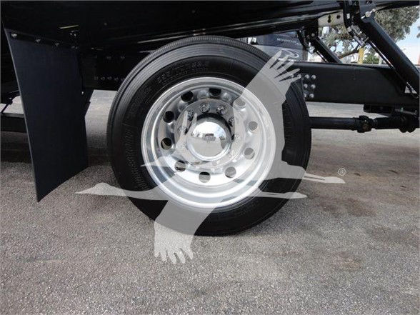 Truck wheel and suspension undercarriage of a 2023 Mack MD6 with a polished silver wheel and tire, visible FRAME and U-bolts.