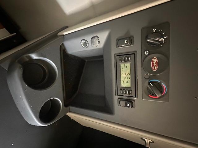 Peterbilt 579 cab interior panel showing cup holders, switch gear, digital display, and climate controls with Peterbilt logo.