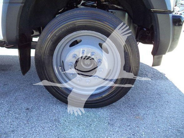 Front wheel of a 2019 Ford F550 dump truck showing Michelin tire and steel wheel. Overlay watermark partially obscures details.