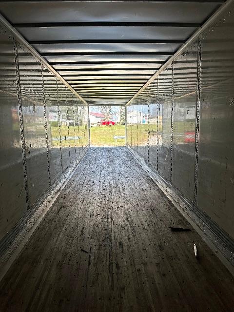 Interior of a 2015 Wabash DuraPlate dry van trailer with metal walls and floor, long aisle to exterior light.