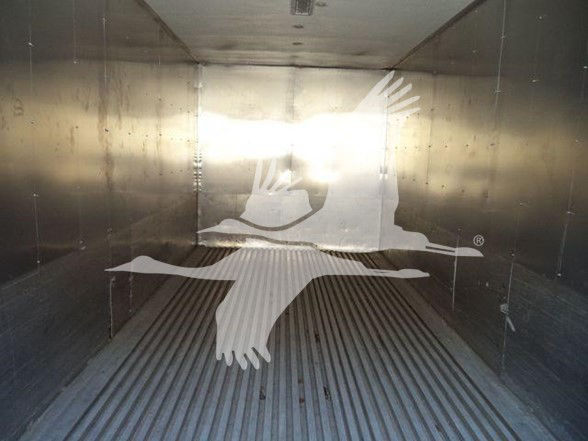 Truck interior photo with a large white dove logo on the back wall of a trailer. No visible text.