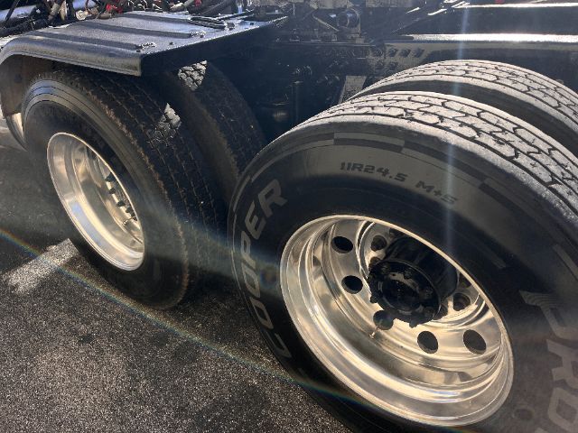 Two rear wheels of a Mack truck chassis with aluminum rims and Goodyear tires showing tread.