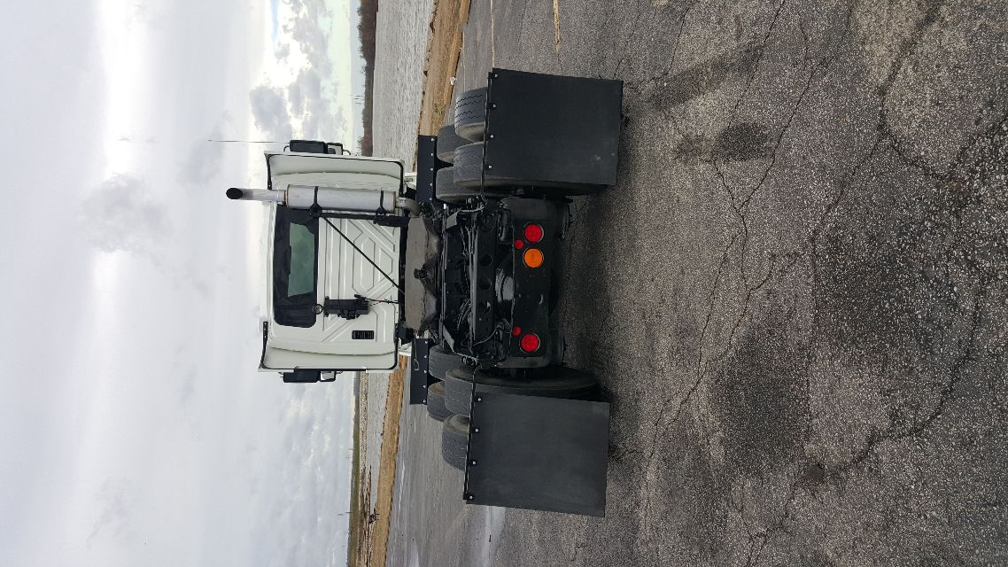 Tractor unit back view showing International 8600 cab with dual rear axles and large mud flaps.