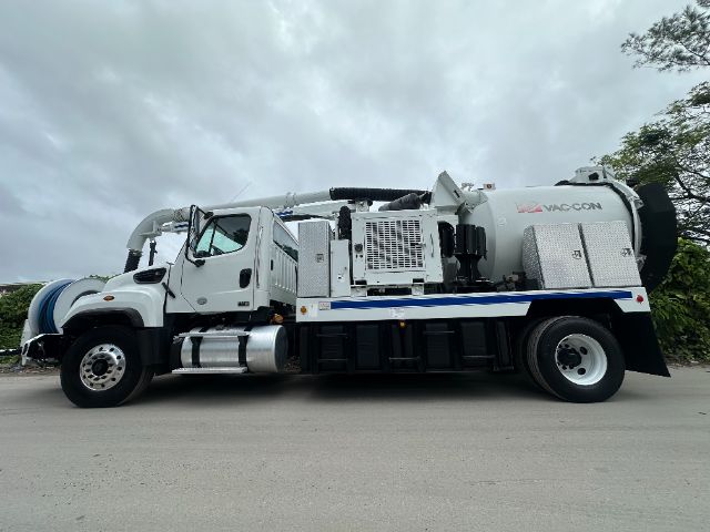 Freightliner 114SD vacuum truck with large rear VAC-CON vacuum tank and hose reel, side view.