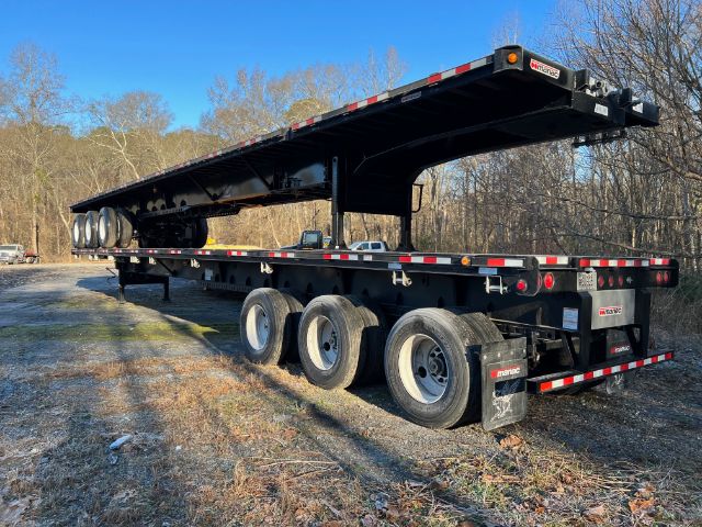 Manac extendable flatbed trailer 53-90 with multiple axles and extendable deck, side rails, and rear lighting.