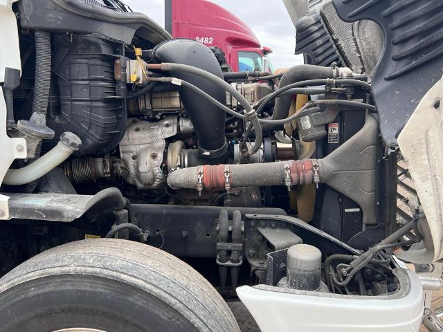 Freightliner Cascadia engine bay showing intake air tube, radiator, hoses, and front suspension components.