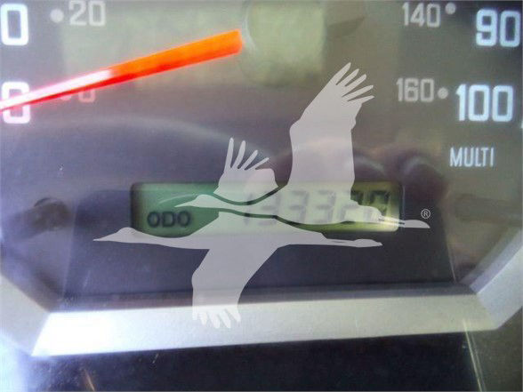 Dashboard odometer showing 9335 miles and gauge labels; blurred background with speedometer and odometer display.