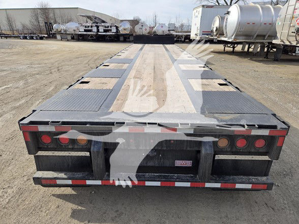 Tri-axle steel drop deck trailer rear view showing taillights, reflective tape, and bumper with BWS plate.