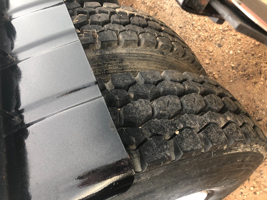Kenworth truck dual rear wheel tread with mud and tire surfaces visible.