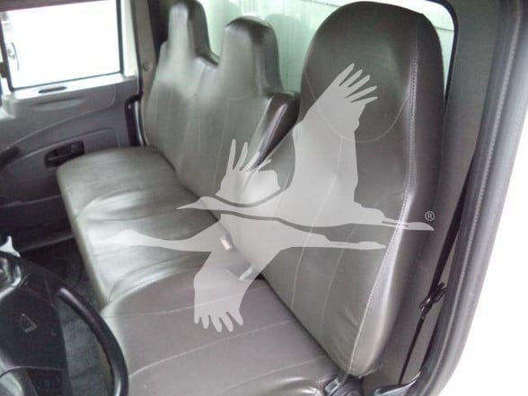 Truck interior showing front bench seat with light gray vinyl, two seat backs, door panel, steering wheel visible; watermark overlay obscures center. No visible text on components.