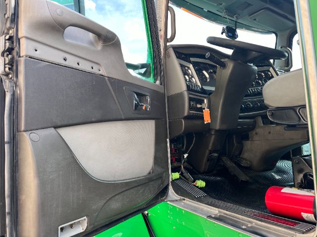 Kenworth T800 cab interior showing driver door open, dashboard and steering wheel, green exterior.