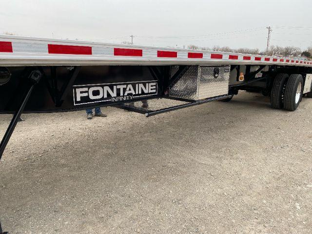 Trailer side showing Fontaine Infinity dunnage rack beneath flatbed trailer.