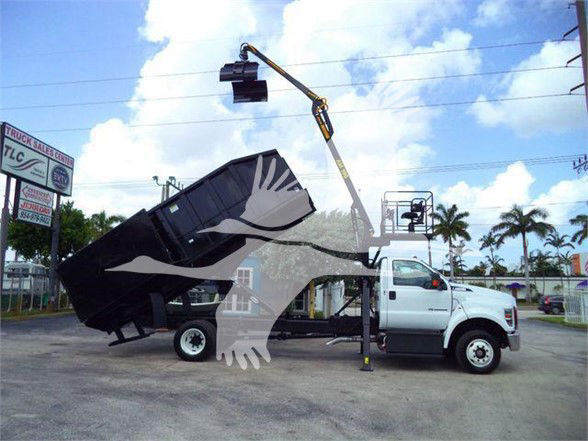 2023 Ford F650 SD grapple truck with a lifted grapple arm and raised dump bed attached to the truck chassis.