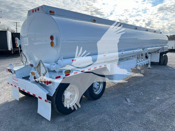2013 Heil 9200 gallon trough-bottom petro tanker trailer viewed from rear-left side showing cylindrical tank, rear lights, and dual-axle configuration.