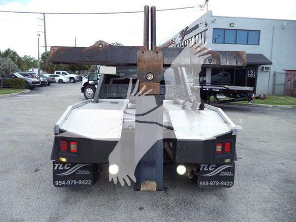 Tow truck hitch and rear view of Ford F-450 tow truck with dual rear lights and branding, in a dealership lot.