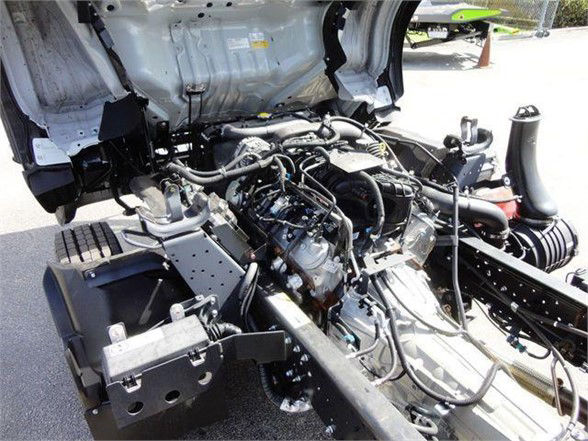 Isuzu NPR HD engine bay showing various hoses, wiring, and components; no clear labels readable.