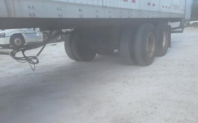 Trailer underside showing dual rear axles and tires of a Vanguard VXP utility trailer.
