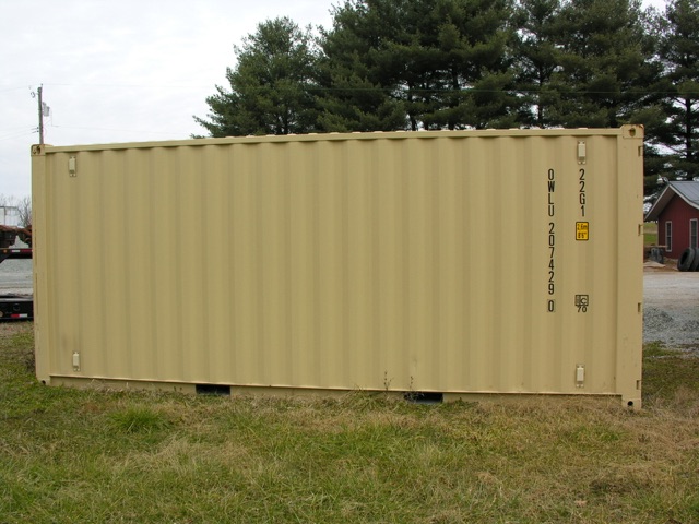 Shipping container on grass with side door and identification markings