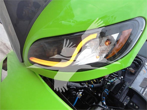 Peterbilt 337 front left headlight area with bright green paint and visible engine bay wiring.