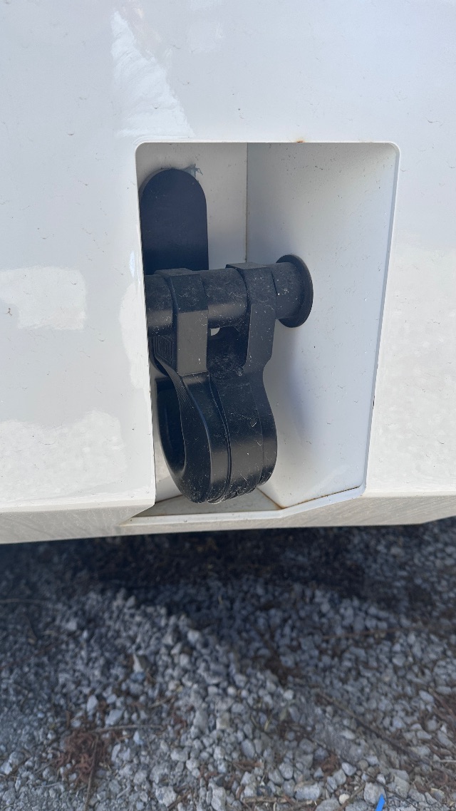 Ford F-550 cab and chassis rear hitch area with black pintle hook mount and receiver, side view, in white paint.