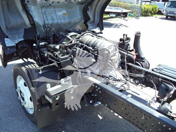 Isuzu NPR HD engine bay with exposed engine compartment and chassis framing showing wiring harnesses and air intake.