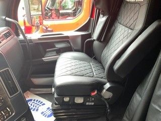 Vehicle interior showing driver seat with diamond stitching and center console in a Western Star 4900 truck.