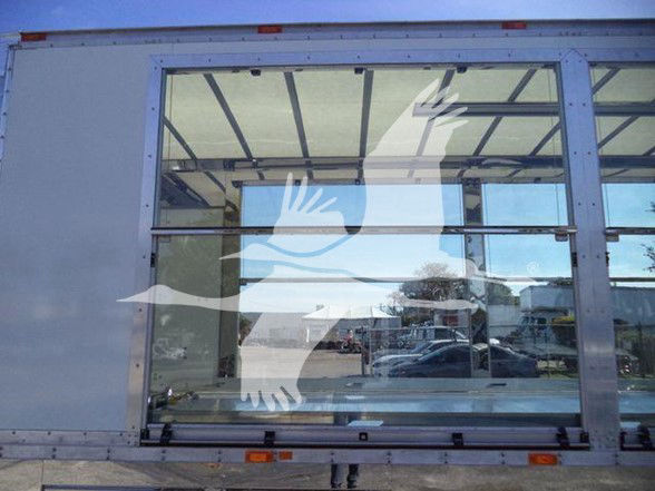 Kenworth T280 door of equipment trailer showing large rear windows with reflection.