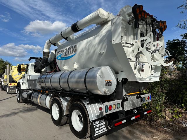 Vacuum truck body with large cylindrical tank and rear mounting, labeled 'Road Sweeper' and 'MDC 2100' on white chassis, side exhaust piping, multiple rear lights.