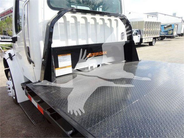 Truck bed of a 2015 Freightliner Business Class M2 106 with a diamond plate flatbed and raised wheel guard.