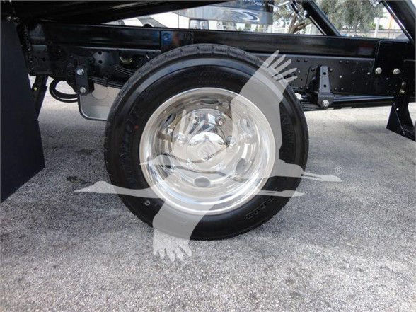 Isuzu NRR truck wheel and chassis visible undercarriage with polished wheel cover.