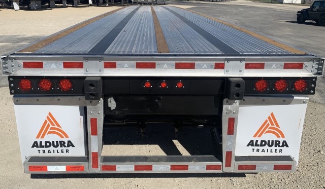 Flatbed trailer rear view showing ALDURA TRAILER branding, aluminum decking with wood strips, and rear lighting and reflective tape.