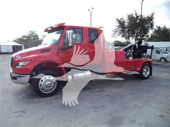 Tow truck side view with red cab and tow equipment at rear; watermark graphic overlay across image.