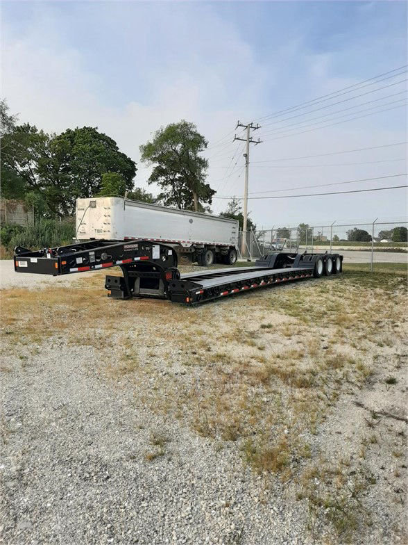 Fontaine 55 ton lowboy trailer with flat deck and multiple axles in an outdoor lot; shows long black frame, ramps, and rear wheels.