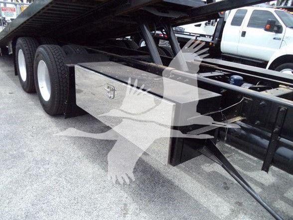 Peterbilt 348 chassis undercarriage showing a metal storage toolbox mounted near the rear wheels.