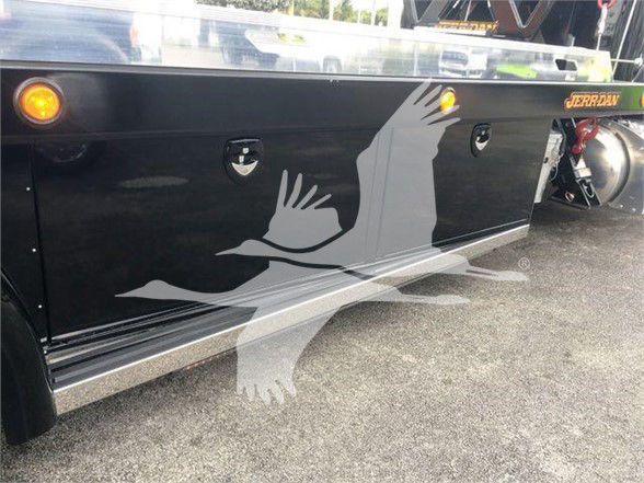 Peterbilt 337 truck side panel with decorative bird graphic in gray and dark paint; small circular reflectors and rear wheel area visible.