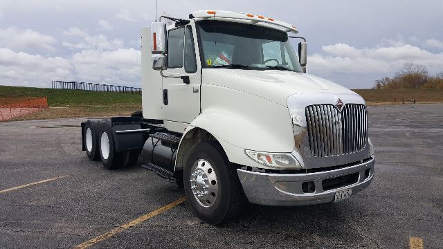 International 8600 conventional daycab truck, white cab with chrome grille, three-axle configuration, bright chrome bumper and mirrors.
