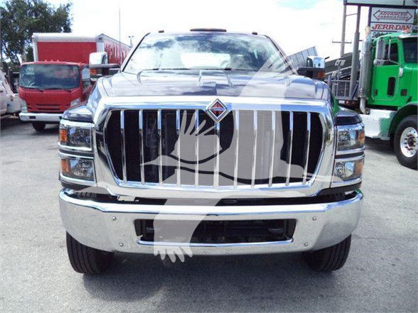 Front view of a 2023 International CV heavy-duty truck with a large chrome grille and bumper; reflection overlay partially covers the grille.